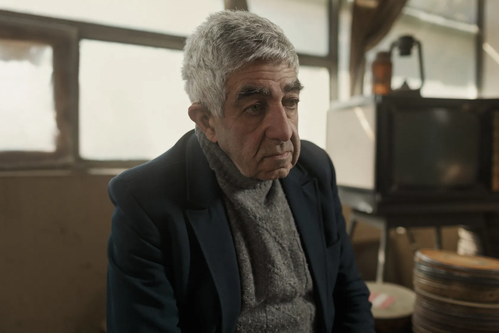 Robert in a grey scarf by the studio window.