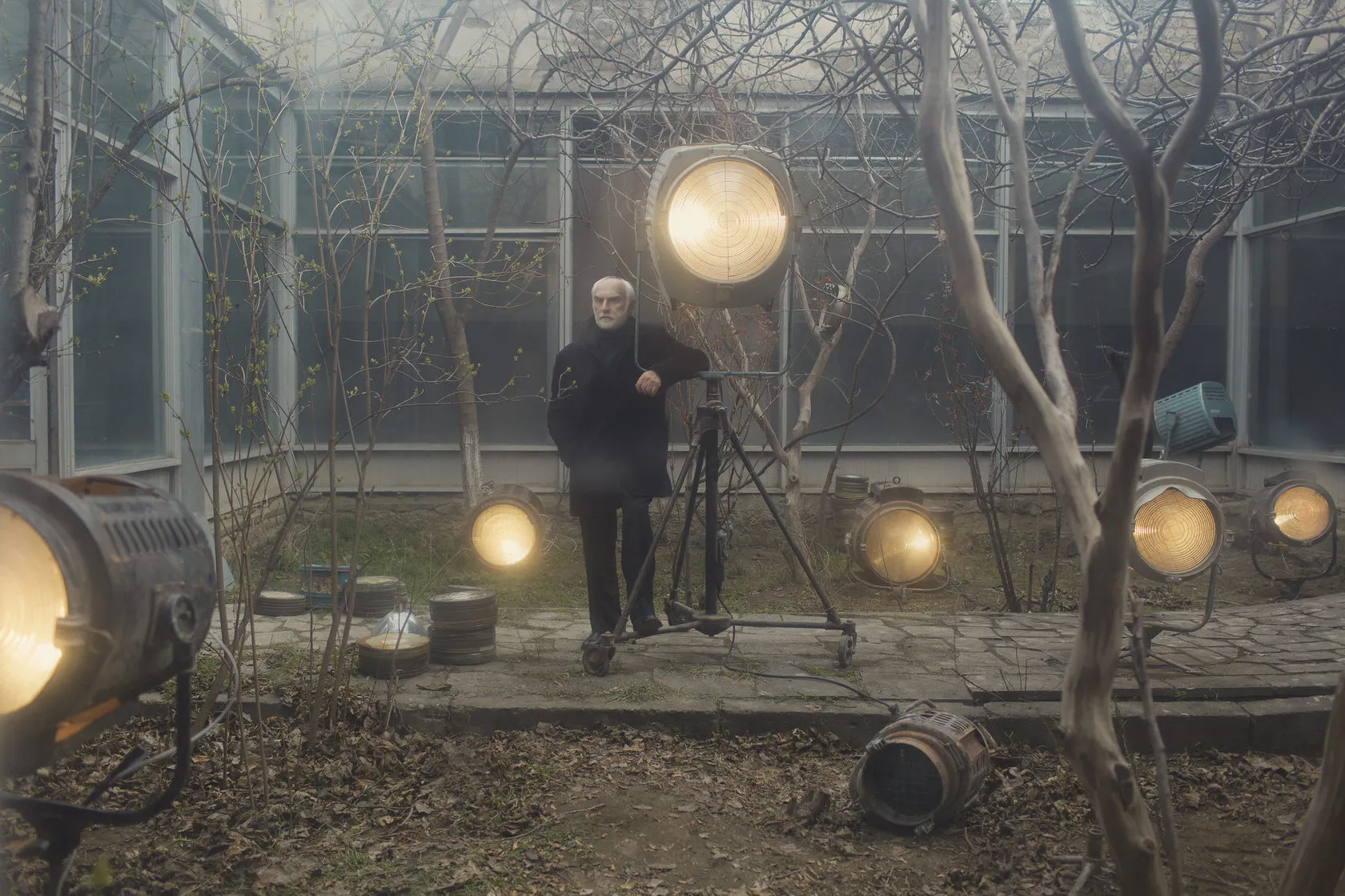 Batoni Merab stands by a spotlight among glowing lamps in the courtyard.