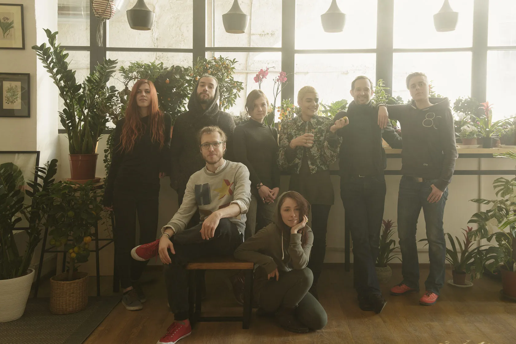 The crew poses together among the plants by the shop’s tall windows.