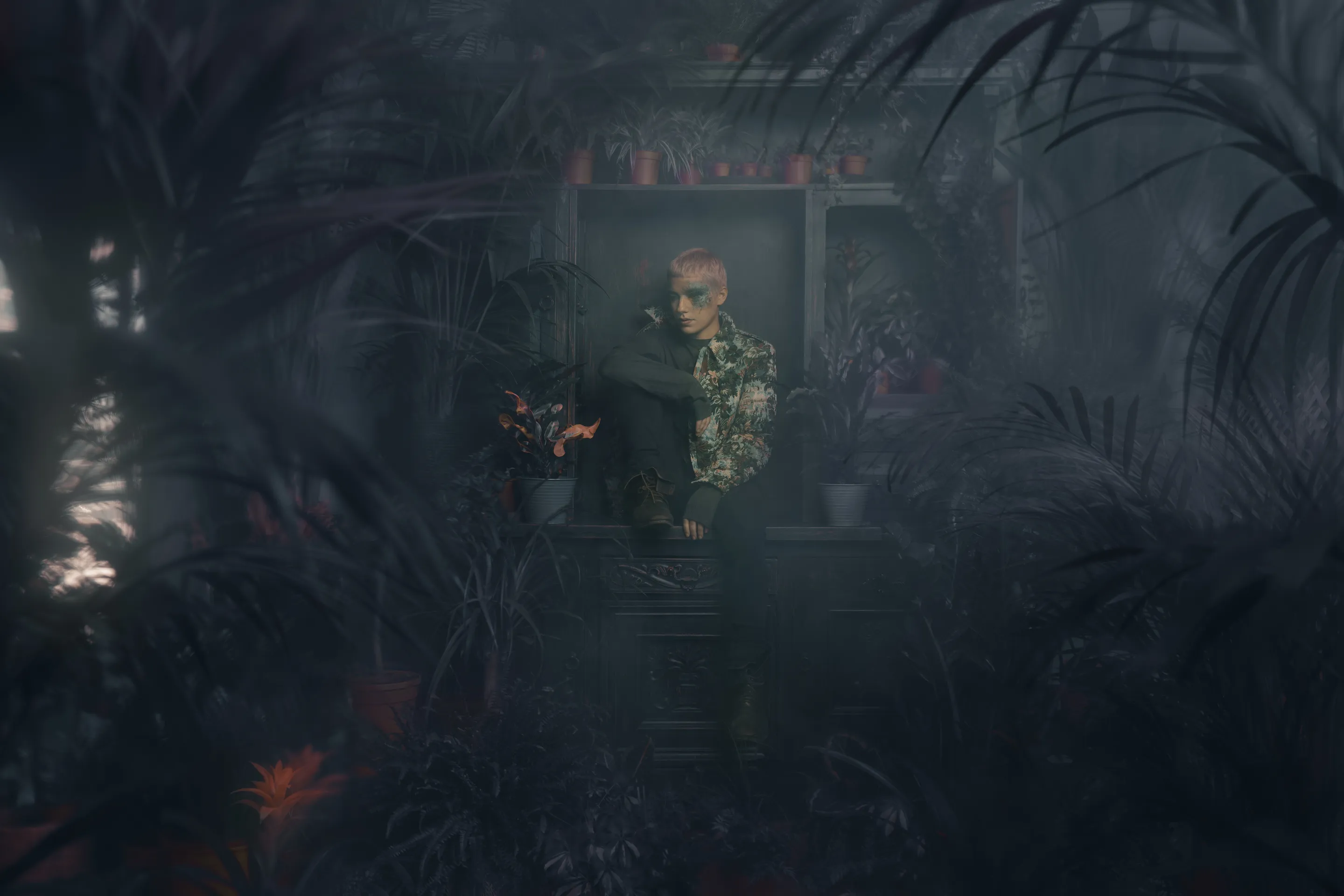 The Jacket campaign by Andrei Kovalev: a model stands in a lit window surrounded by dense studio foliage.