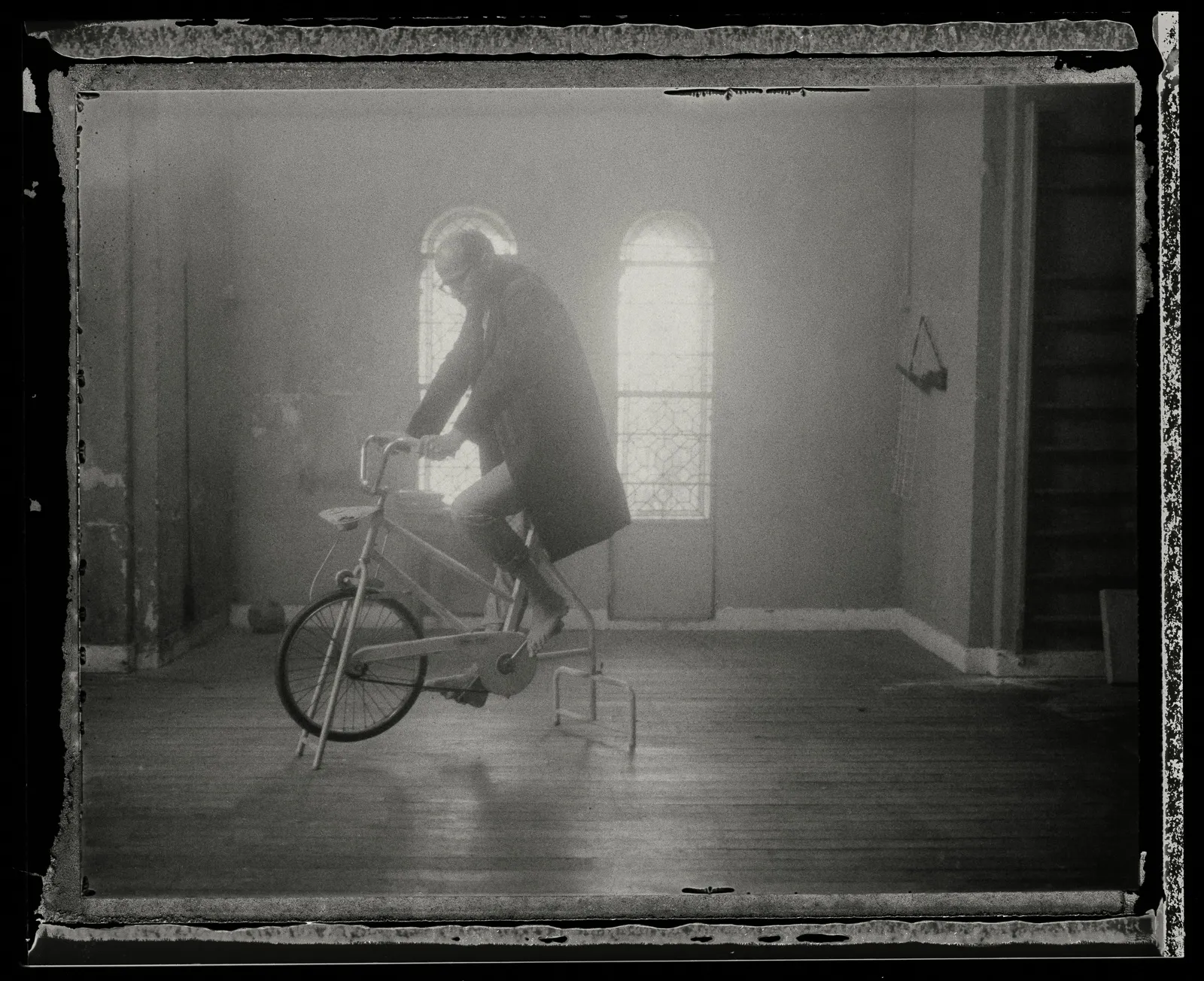 Laurent on the exercise bike in a bright hall, on old instant film.