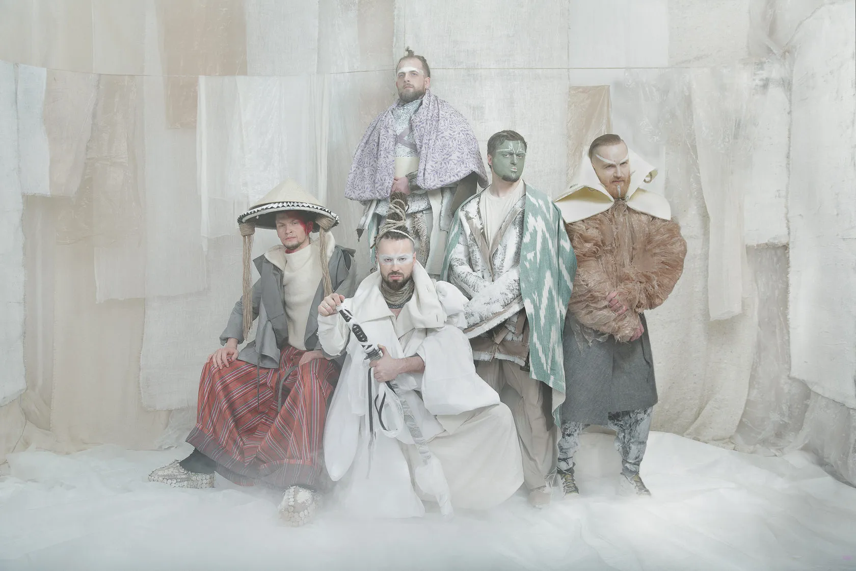The five members of Burito in their White Album costumes pose together on the white set.