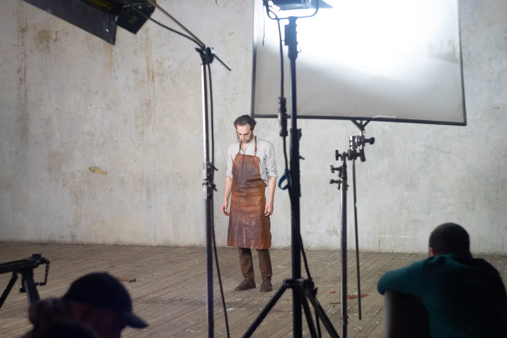 Behind the scenes: the actor in the leather apron stands under a large diffusion screen.
